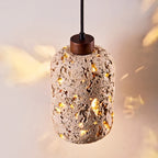 Tufa Calcified Stone Pendant Light warm ambient lighting in evening dining room setting