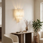 Tubular glass wall sconce in bedroom setting