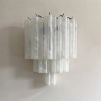 Tubular glass wall sconce in hallway setting